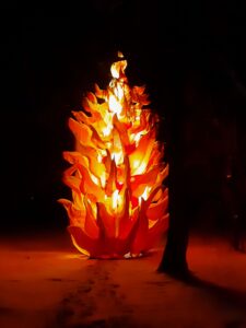 Iluminacja świetlna w formie dużego pomarańczowego ogniska ustawiona na śniegu