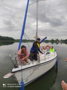 Kadłub białego jachtu na jeziorze z czwórką dorosłych osób