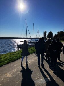 Ciemne sylwetki ludzi na tle jasno oświetlonego słońcem zbiornika wodnego