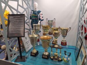 Duża ilość pucharów manekin w koszulce zawodnika oraz zdjęcia w ramach związane z drużyną piłki ręcznej Montex Lublin