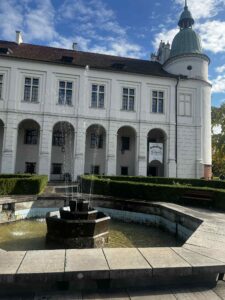 Fontanna a za nią widoczna fasada muzeum - zamku w Baranowie Sandomierskim