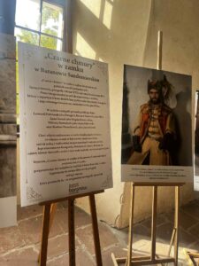 W pałacowym wnętrzu ustawione na sztalugach dwie tablice informacyjne z tekstem i fotografią