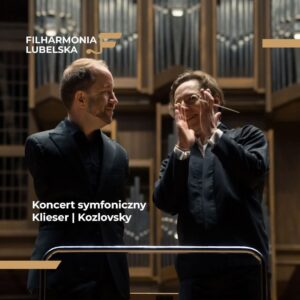 Dwóch mężczyzn patrzących na siebie i stojących na tle organów