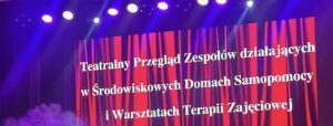 Projekcja na ścianie przedstawiająca czerwoną kurtynę i umieszczoną na jej tle nazwę przeglądu teatralnego