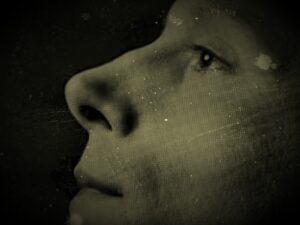 Zdjecie zbliżenia twarzy aktora Eryka Kulma stylizowane na starą i porysowaną fotografię