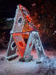 Plenerowa i kolorowa iluminacja świetlna z wielu lampek w formie piramidy ustawionej z siedmiu kart do gry