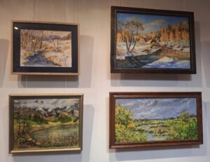 Cztery obrazy w ramach malowane farbami i przedstawiające pejzaże wiosenne i zimowe