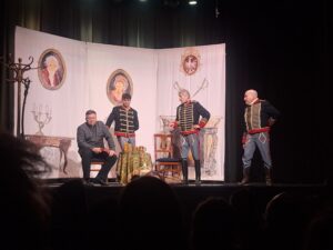 Scena rodzajowa z przedstawienia teatralnego z czterema mężczyznami - w tym trzech w mundurach huzarów