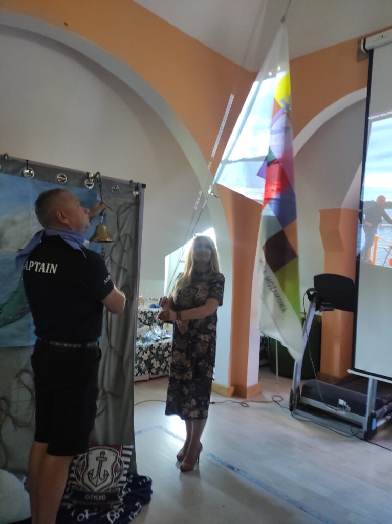 Mężczyzna i kobieta we wnętrzu stojący pod kolorową chorągwią zawieszoną na sznurku
